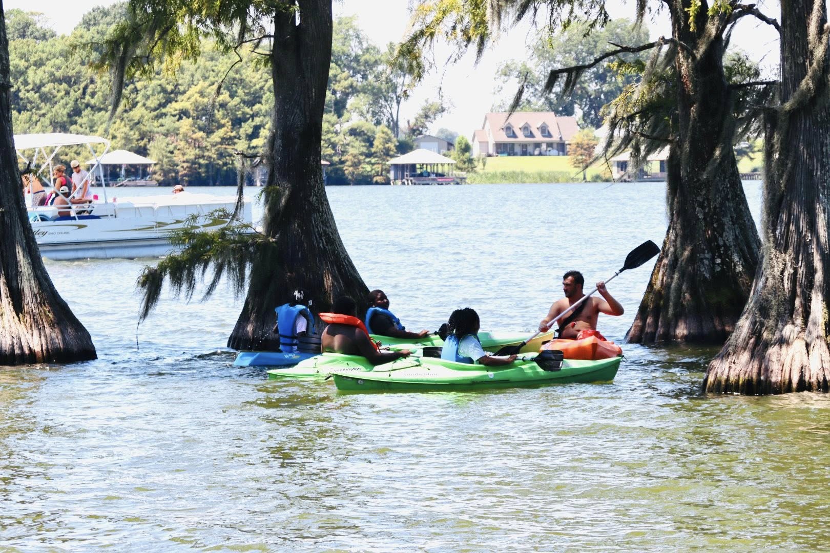 Five people kayaking in a lake.